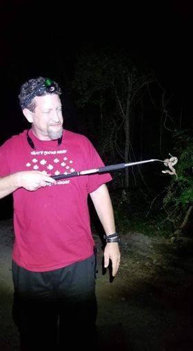 Jason Landers holding a snake hook outdoors